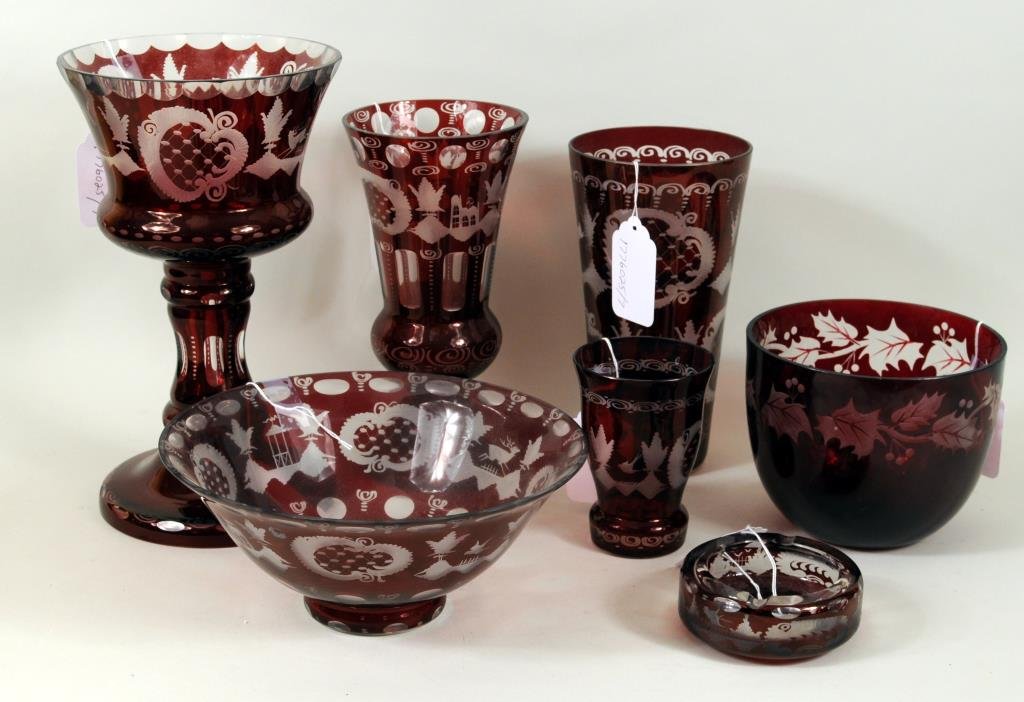 Seven Pieces Bohemian Ruby Etched Glassware: Seven pieces of Bohemian ruby etched glassware with similar design comprising two footed glass vases, a tall vase, two bowls, small urn and ashtray. 1 3/4" high, 4" diameter to 11 3/4" high, 7" diamet