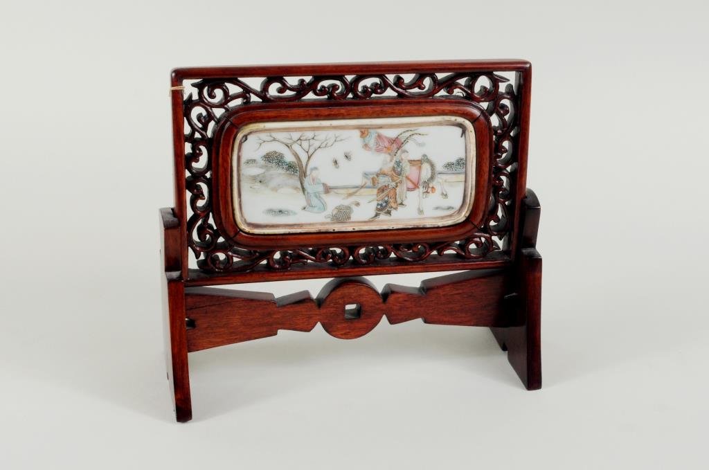Chinese Porcelain & Wood Table Screen: Chinese porcelain and wood table screen, plaque depicting a nobleman with horse and attendants. 6 1/2" high, 7 1/2" wide. Condition: gilt, enamel wear, loss, age crack to stand.