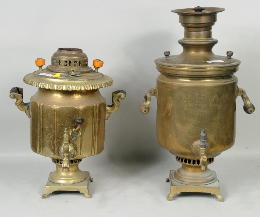 Two Russian Antique Brass Samovars: Two brass Samovars, the larger with Russian stamps. 16" high, 12" wide to 19 1/2" high, 11 1/2" wide. Condition: dents, smaller lacking lid with uneven base.