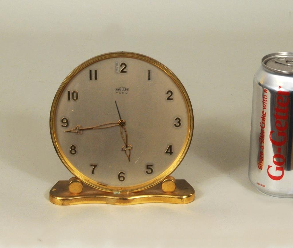 Angelus Yard Desk Clock: Angelus Yard desk clock, in running condition. 5 3/8" high, 5 1/4" wide. Condition: scratch to glass, 1 of numeral 12 detached, in case.