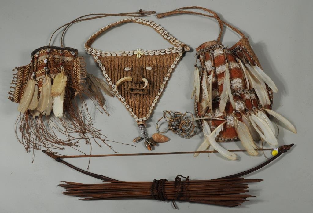 Group Tribal Items: Group tribal items comprising three shell, feather, fiber and tusk bags and a bow and bundle of arrows. 9 1/2" high, 10 1/2" wide to 32 1/2" long, 5" wide.