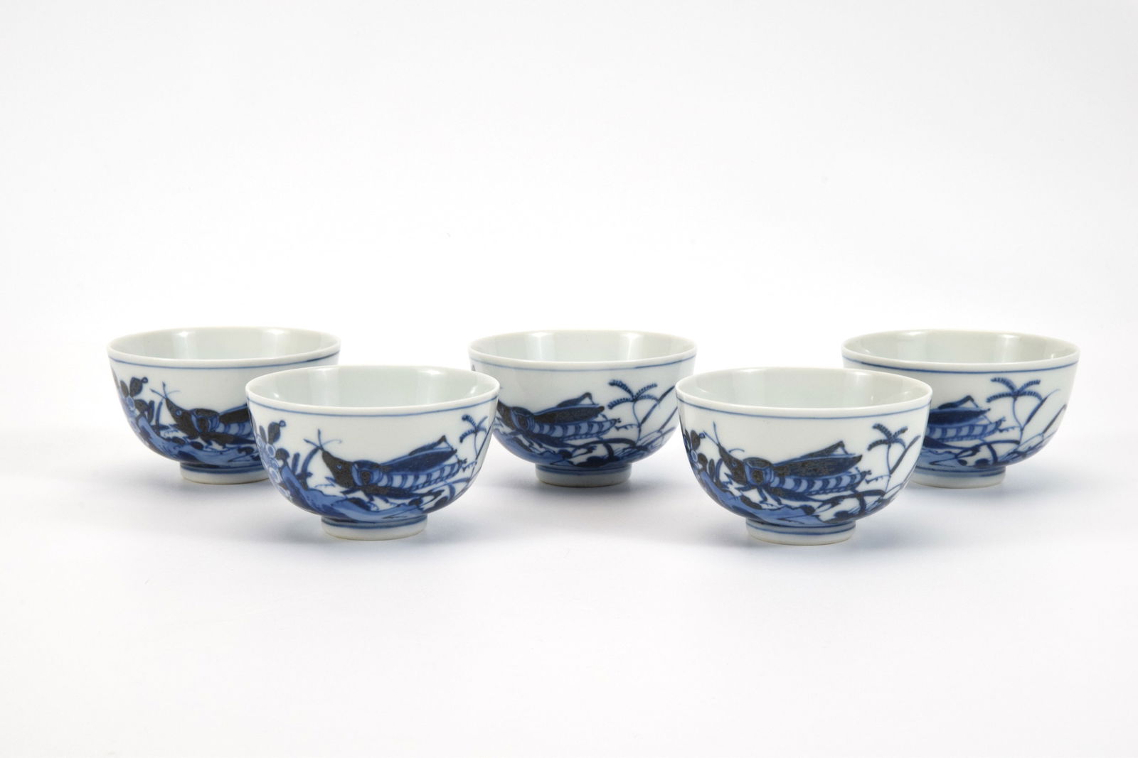 Chikusen Miura II:Set of 5 Blue & White Teacups: A set of five tea cups by Miura Chikusen II, exquisitely decorated in cobalt blue with insects and wild grasses. The delicate brushwork and lyrical composition capture a moment of nature’s quiet vit