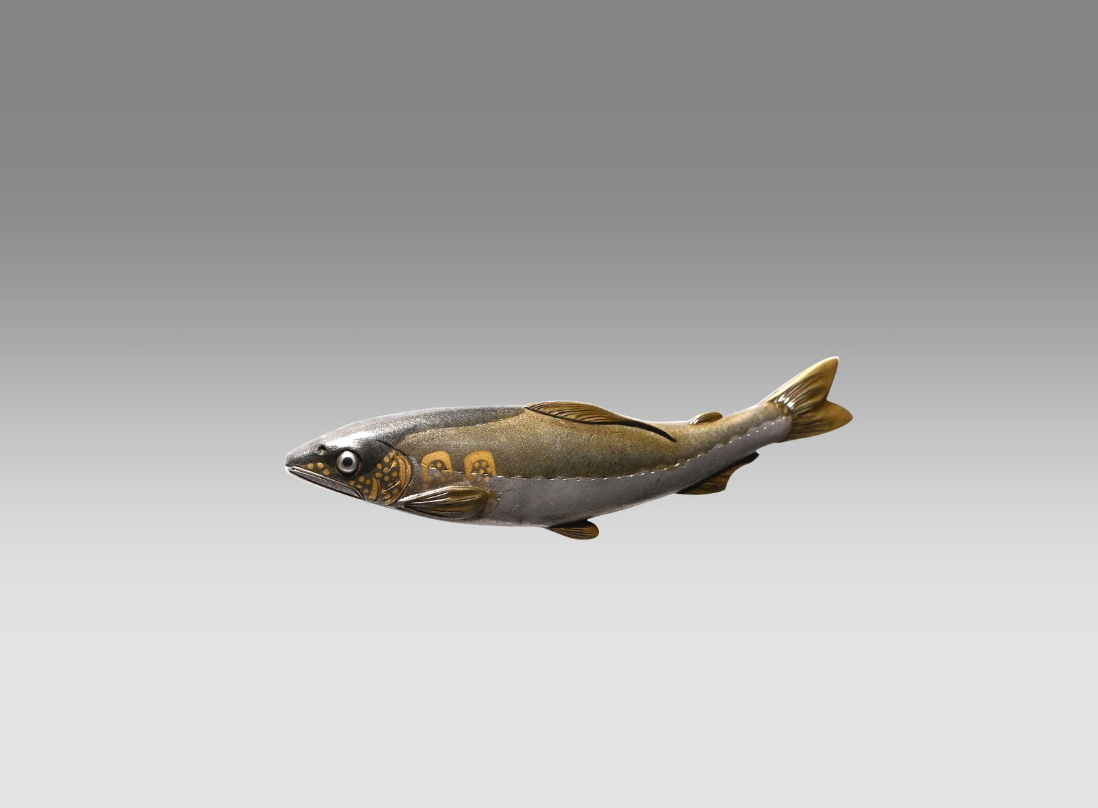 Tobacco Fitting with Gold and Silver Inlay by Unno Kiyoshige: This finely crafted tobacco pouch fitting in the form of a fish is a work by Unno Shomin, one of the foremost metal artists of the Meiji period. Although modest in size, it embodies exceptional techni