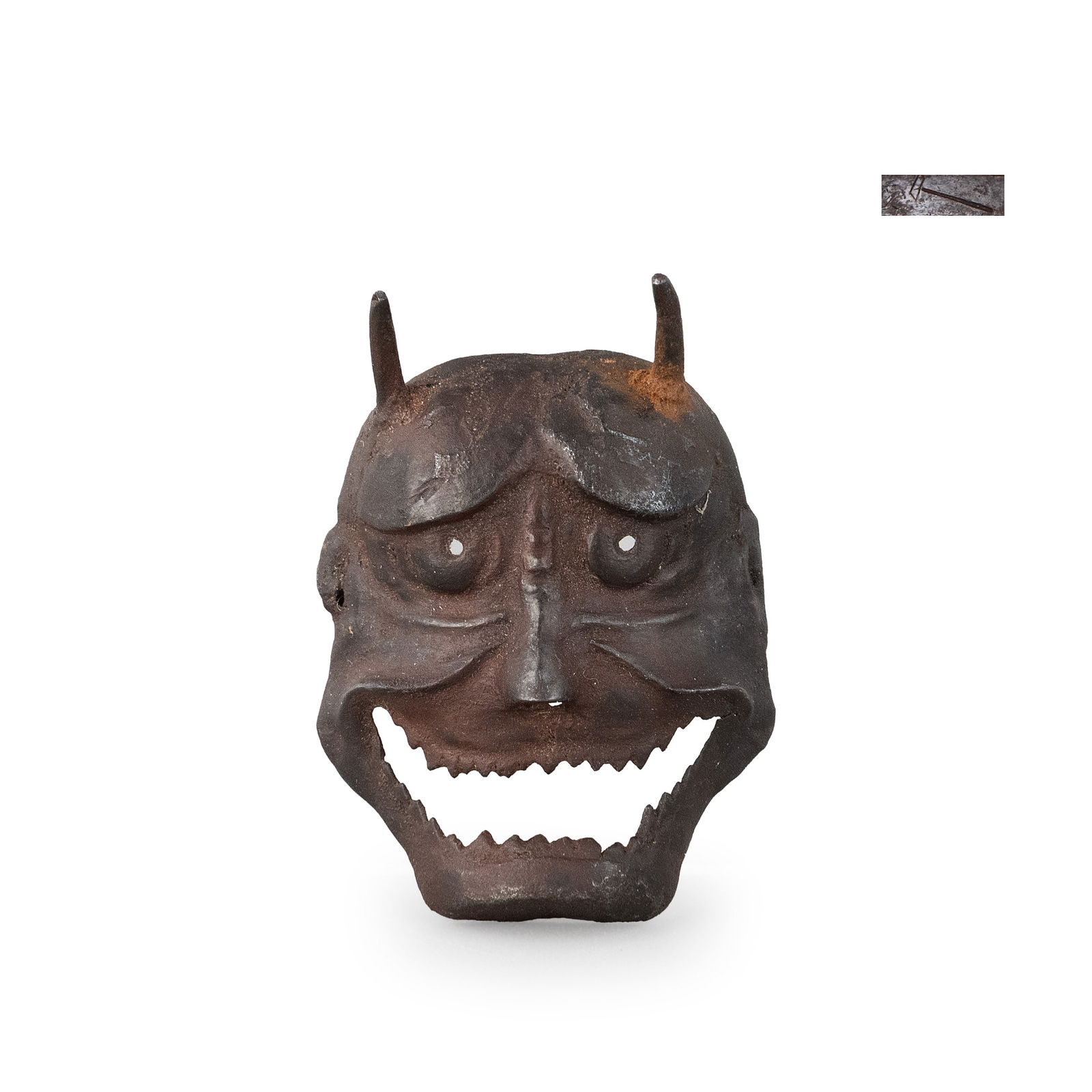 Iron Netsuke by Myochin Yoshihisa: Hammered and shaped from iron sheet, this compact netsuke depicts a Hannya mask with sharply defined horns, furrowed brows and a wide, open mouth revealing serrated teeth. The surface retains a deep b