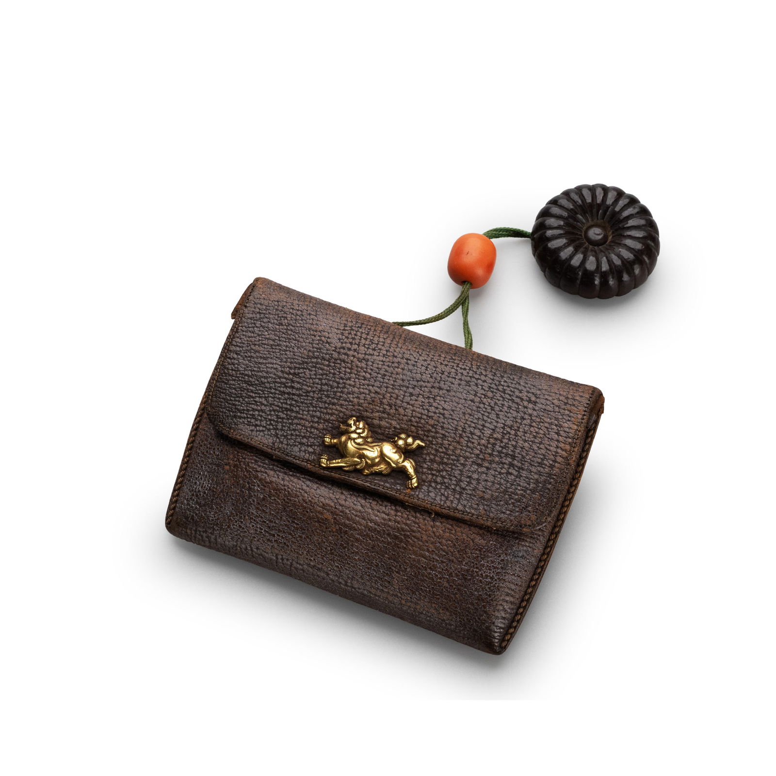 Tobacco Case with Gilded Shishi Inlay: A Japanese tobacco pouch of rectangular form in finely textured brown leather, fitted with a gilt metal clasp ornamented with a recumbent shishi rendered in relief. The lion figure is crisply modeled,