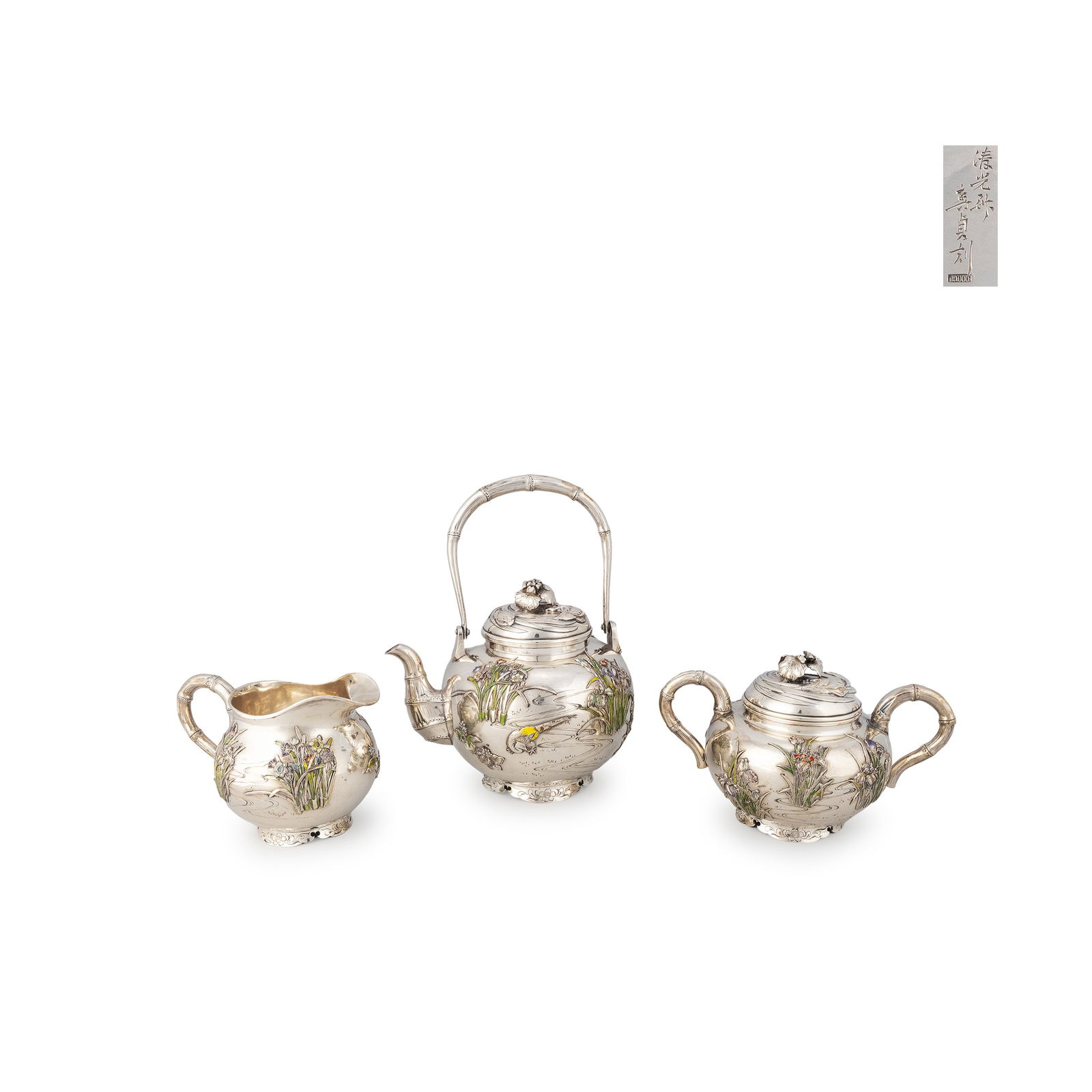 Pure Silver Tea Set with Cloisonné Inlay by Shimizu: A Japanese sterling silver tea set, signed “Shimizu saku" and “Toshisada koku," comprising a kettle-form teapot with swing handle, a lidded sugar bowl, and a creamer. Each piece is worked with flo