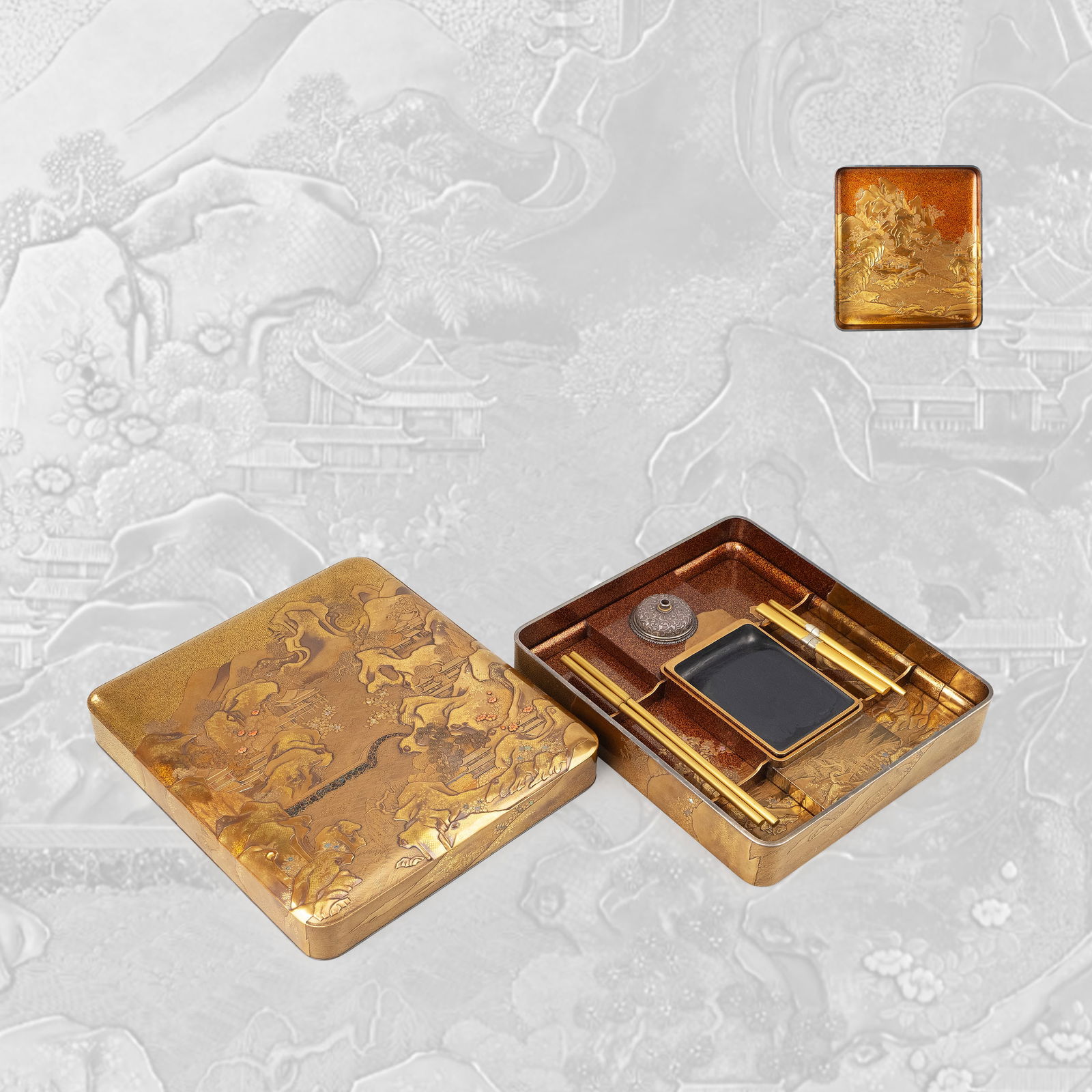 Suzuri-bako with Gold Maki-e: A refined lacquer writing box decorated in gold maki-e with an expansive landscape composition. The cover presents a continuous scene of mountainous terrain, pavilions, bridges, and flowing water, ren
