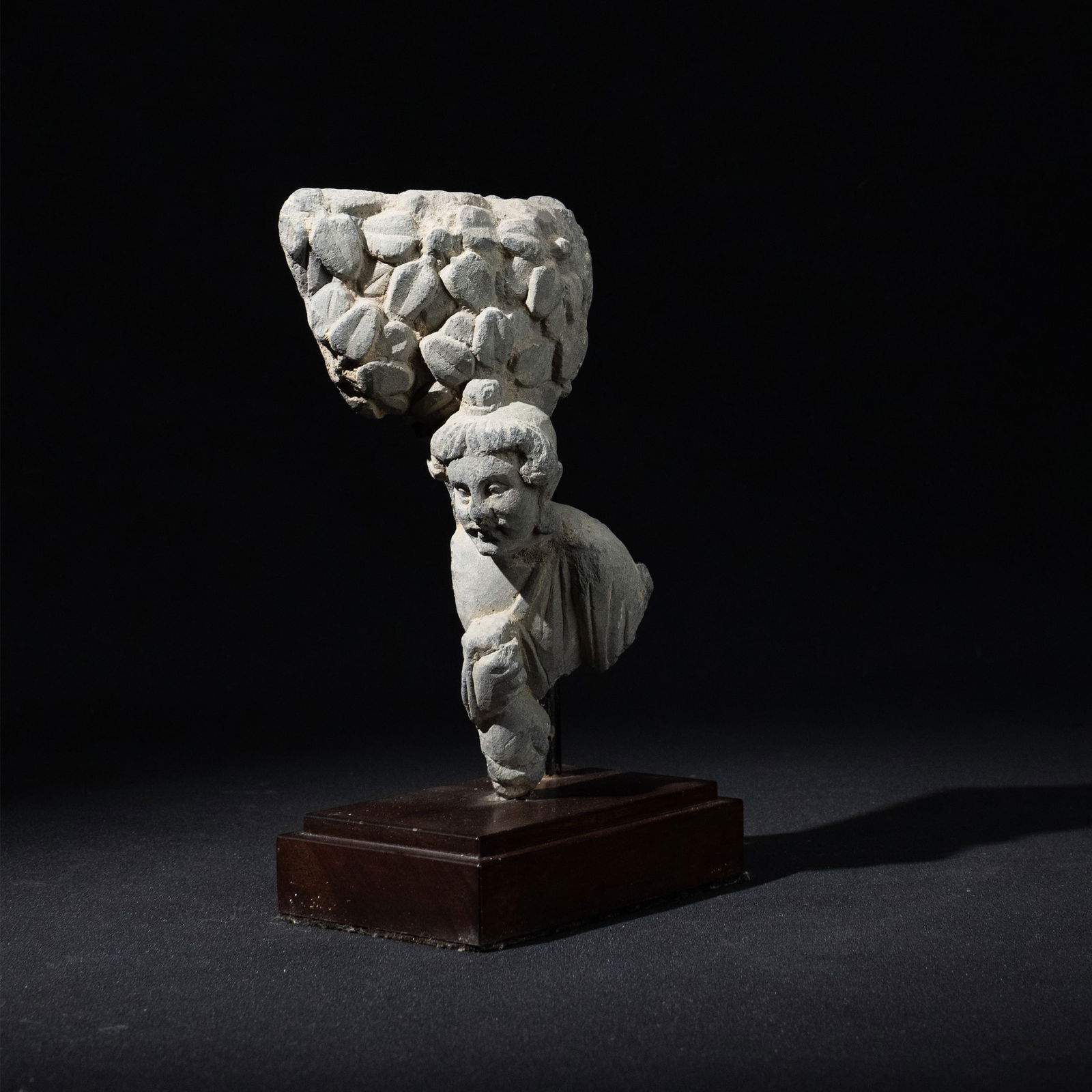 Gandhara Sculpture with Certificate by Kurita Isao: Carved in grey schist, the fragment represents a standing Brahman figure beneath a stylized tree canopy. The figure is rendered in high relief, with softly modeled facial features, wavy hair, and drap