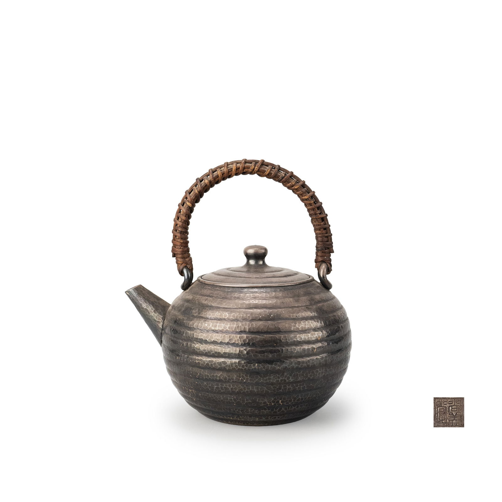 Silver Kettle By Shobido: A silver kettle by Sh?bid?, of rounded imo-gata [taro-shaped] form. The body is encircled with horizontal hammered bands, the carefully executed tsuchime surface creating lively reflections and