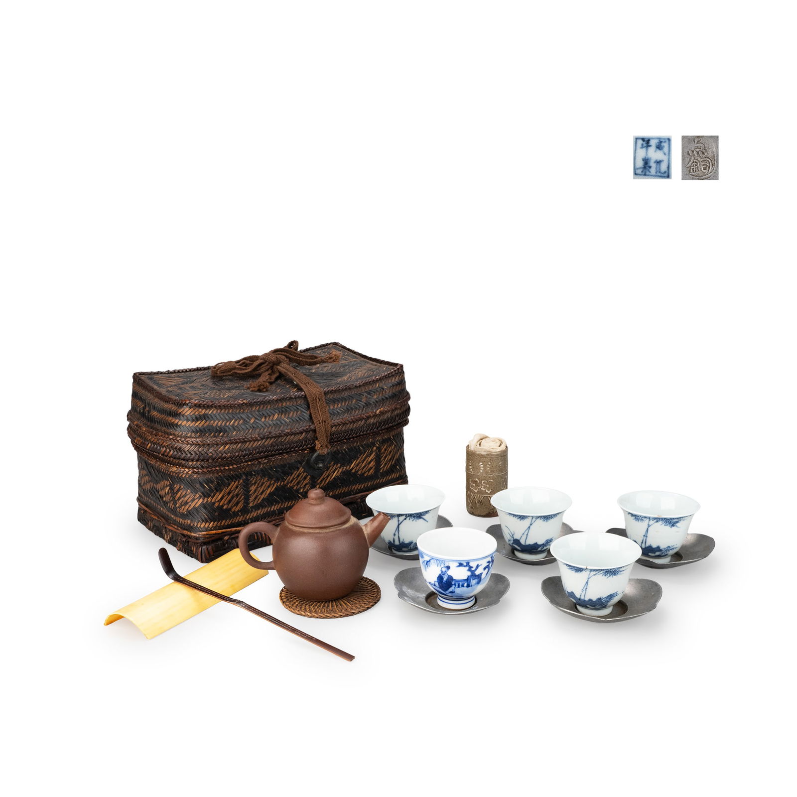 Sencha Tea Utensil Set: A Japanese sencha tea set comprising a woven bamboo carrying chest, a Yixing clay teapot, five blue and white porcelain cups, five metal saucers, a bamboo tea scoop, and associated accessories