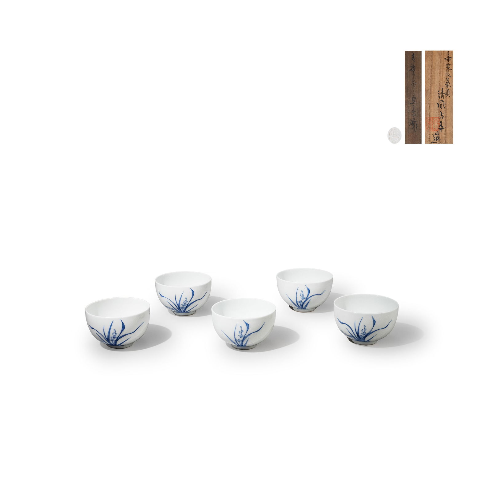 Five Tea Bowls By Seifu Yohei III ,Tomobako: The bowls feature a refined, upright form, with orchid leaves rendered gracefully in crisp underglaze cobalt [gosu] brushwork. The composition skillfully utilizes empty space, creating a serene and el
