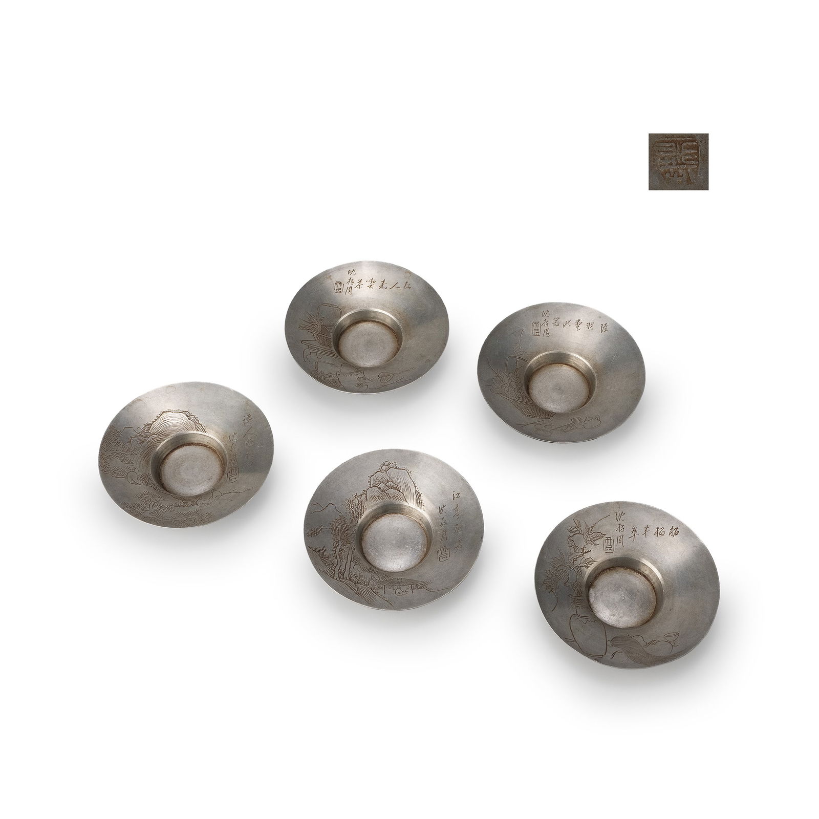 Set of Five Pewter Tea Saucers: Each saucer of circular form with a raised central cup rest, the surface finely engraved with varied compositions including mountainous landscapes, scholar’s objects and archaic vessels. The decorat