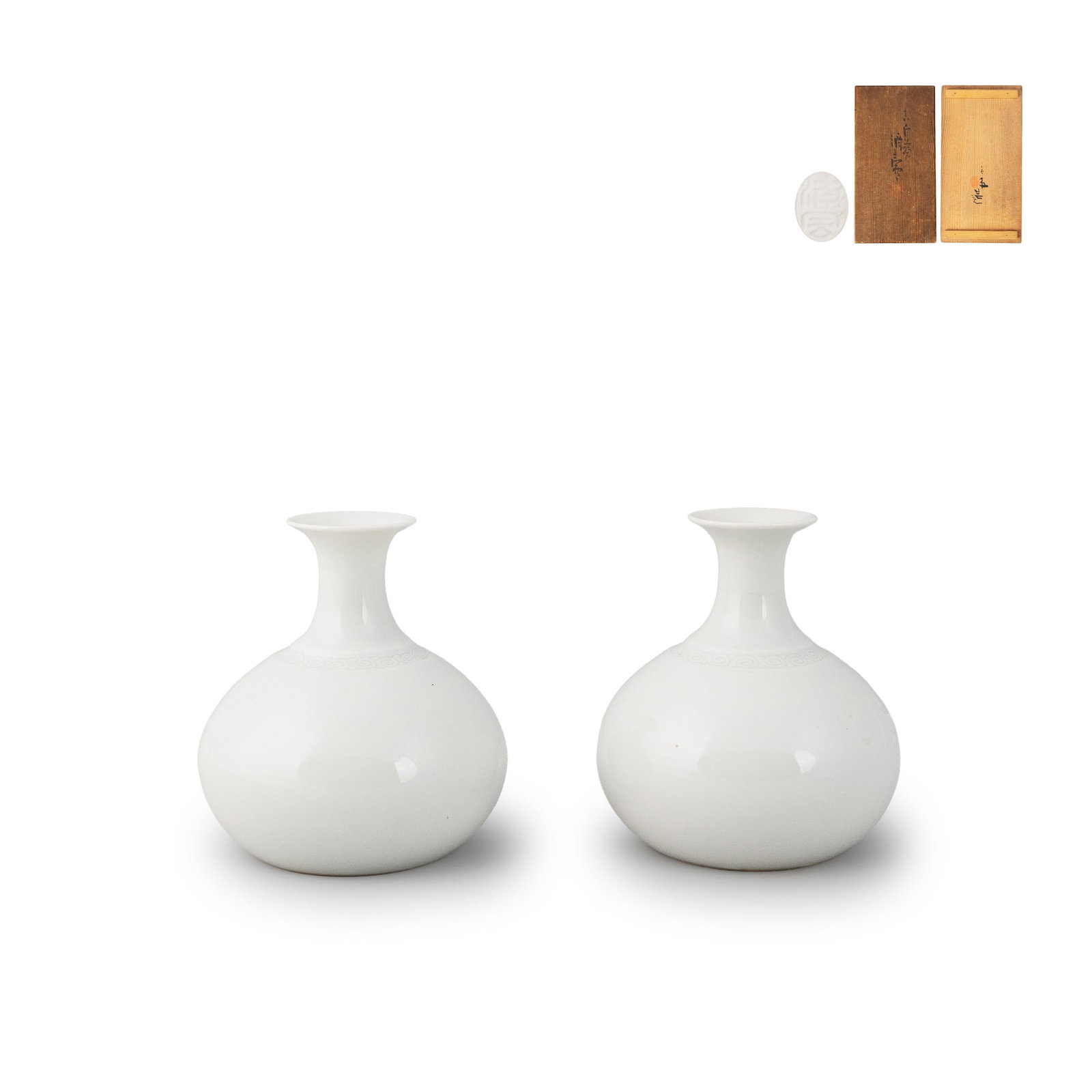 Pair Sake Bottles by Seifu Yohei, Boxed: This is a pair of white porcelain sake flasks [tokkuri] by Seifu Yohei, accompanied by the original box. Each vessel features a rounded body rising to a slender neck with a gently flared rim, forming 