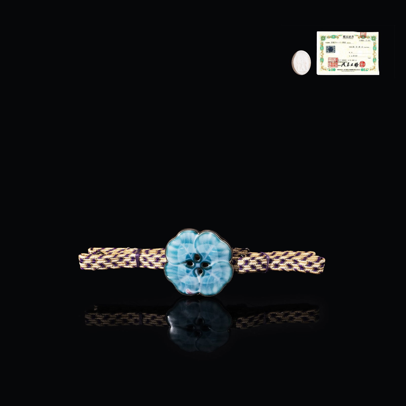 Itaya Hazan Obi Clasp with Certificate: This is a refined overglaze porcelain obi clasp by Itaya Hazan, a master of modern Japanese ceramics. The piece is formed as a four-lobed clover and covered in a soft celadon-toned glaze, presenting a