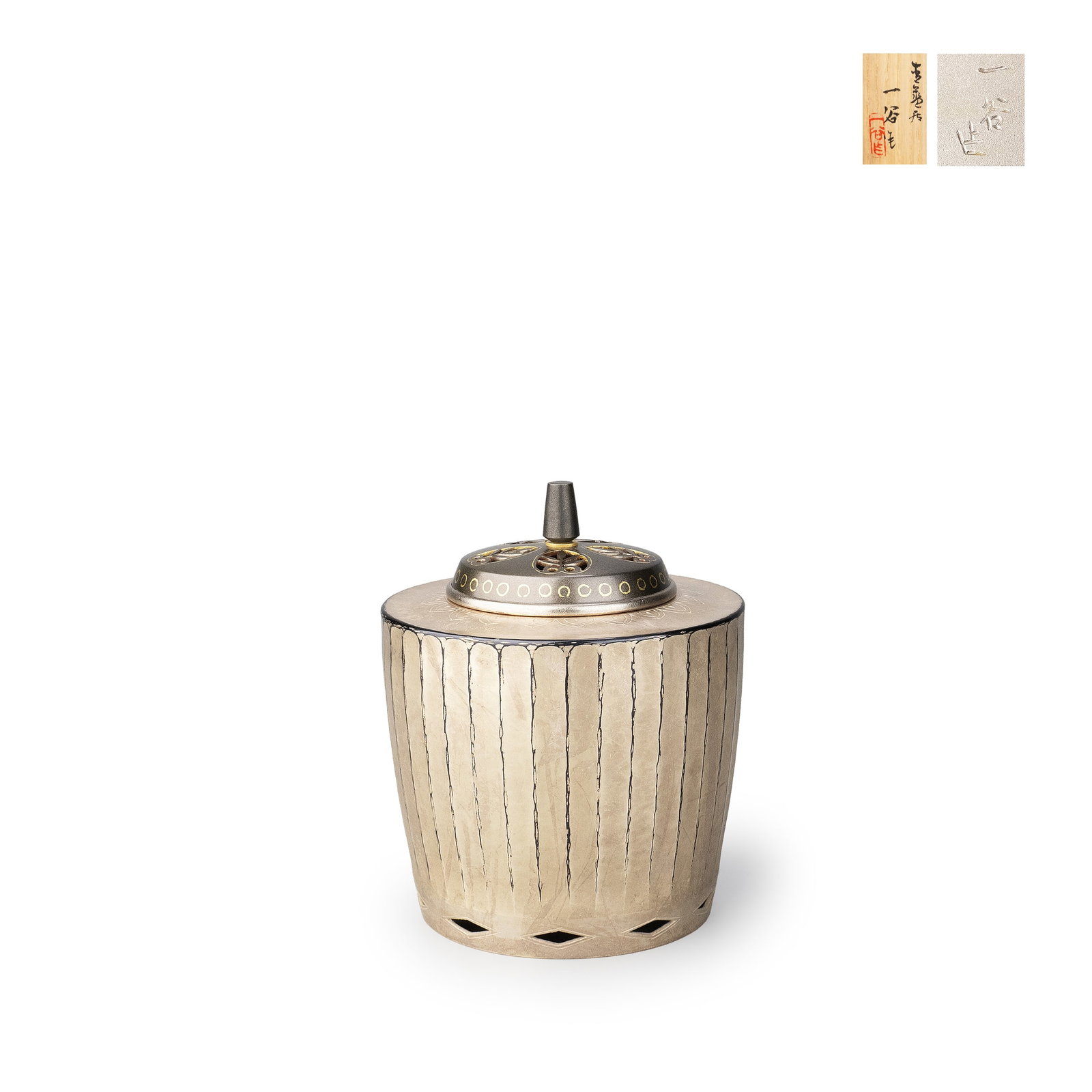 Incense Burner by Kashima Ikkoku: This incense burner is crafted in shakudo, presenting a refined cylindrical form with clean, upright lines that convey a sense of balance and restraint. The exterior is finished with fine vertical str