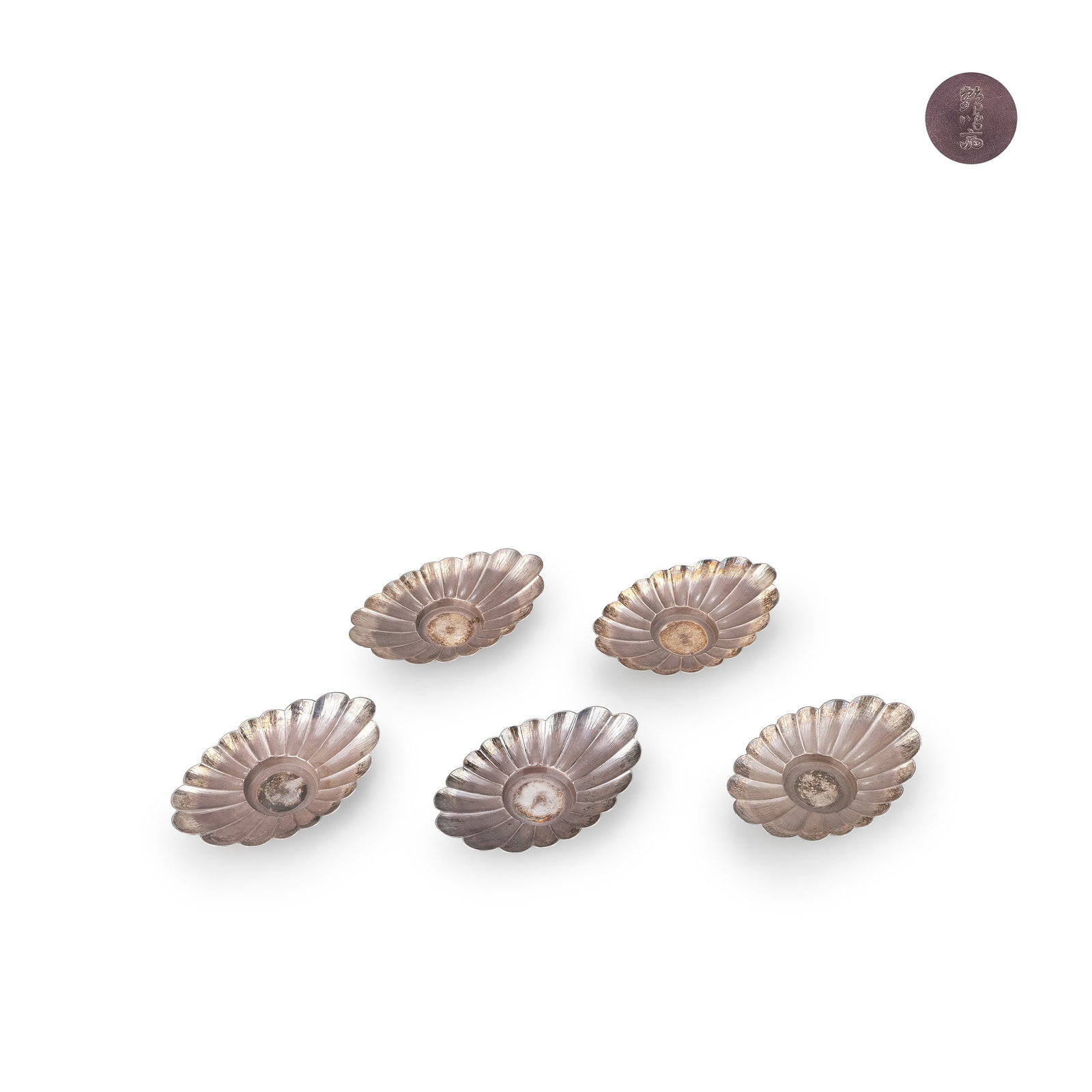 Set of Five Silver Saucers by Kakumeisai: This set of tea saucers, comprising five pieces, is crafted in pure silver by Kakumeisai. The design draws on the chrysanthemum motif, with petals radiating outward in a balanced and rhythmic composit