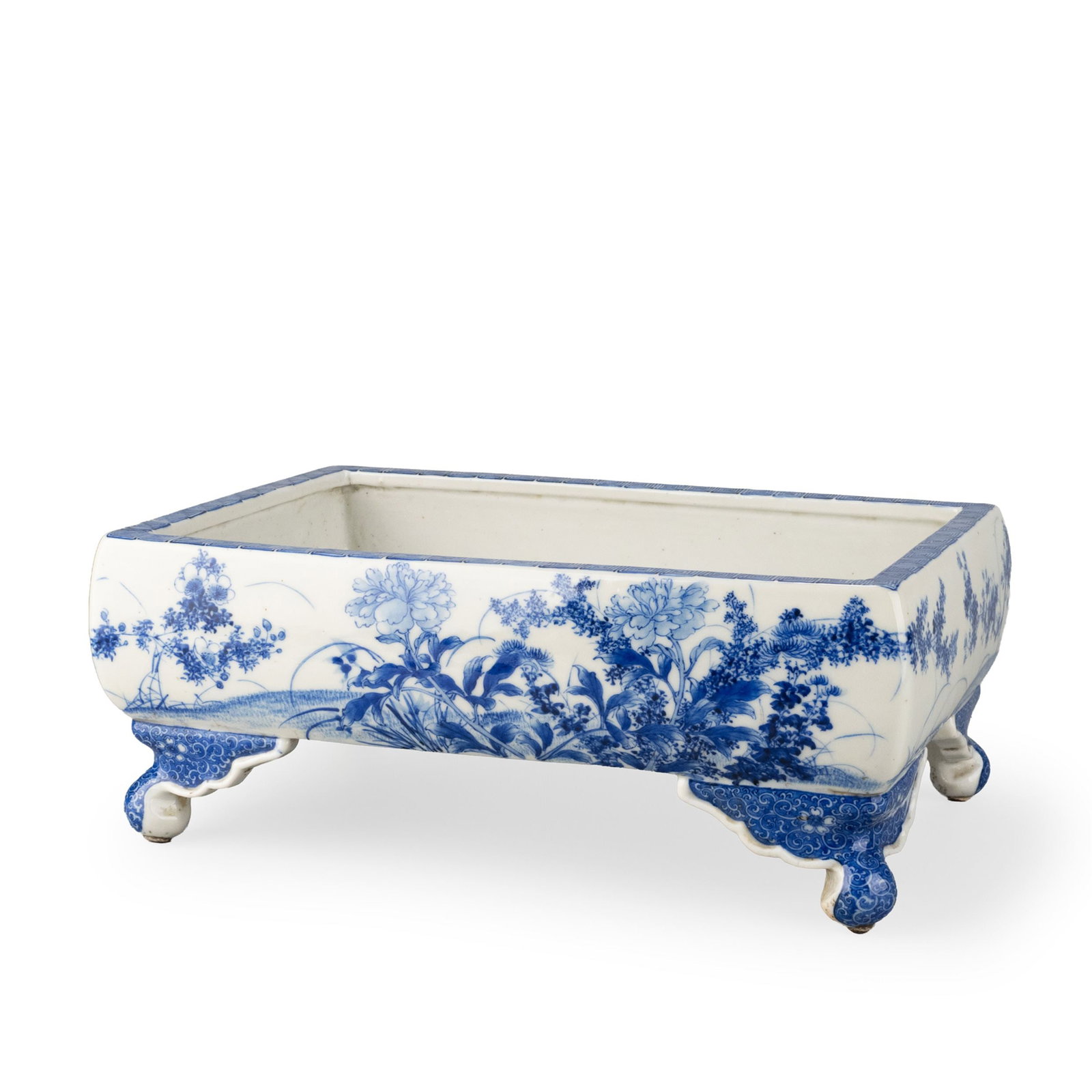 Seto Ware Suiban: Decorated in underglaze blue with an elegant continuous landscape of seasonal flowers. The gently rounded corners and gracefully shaped bracket feet lend the vessel a refined architectural form. Peoni