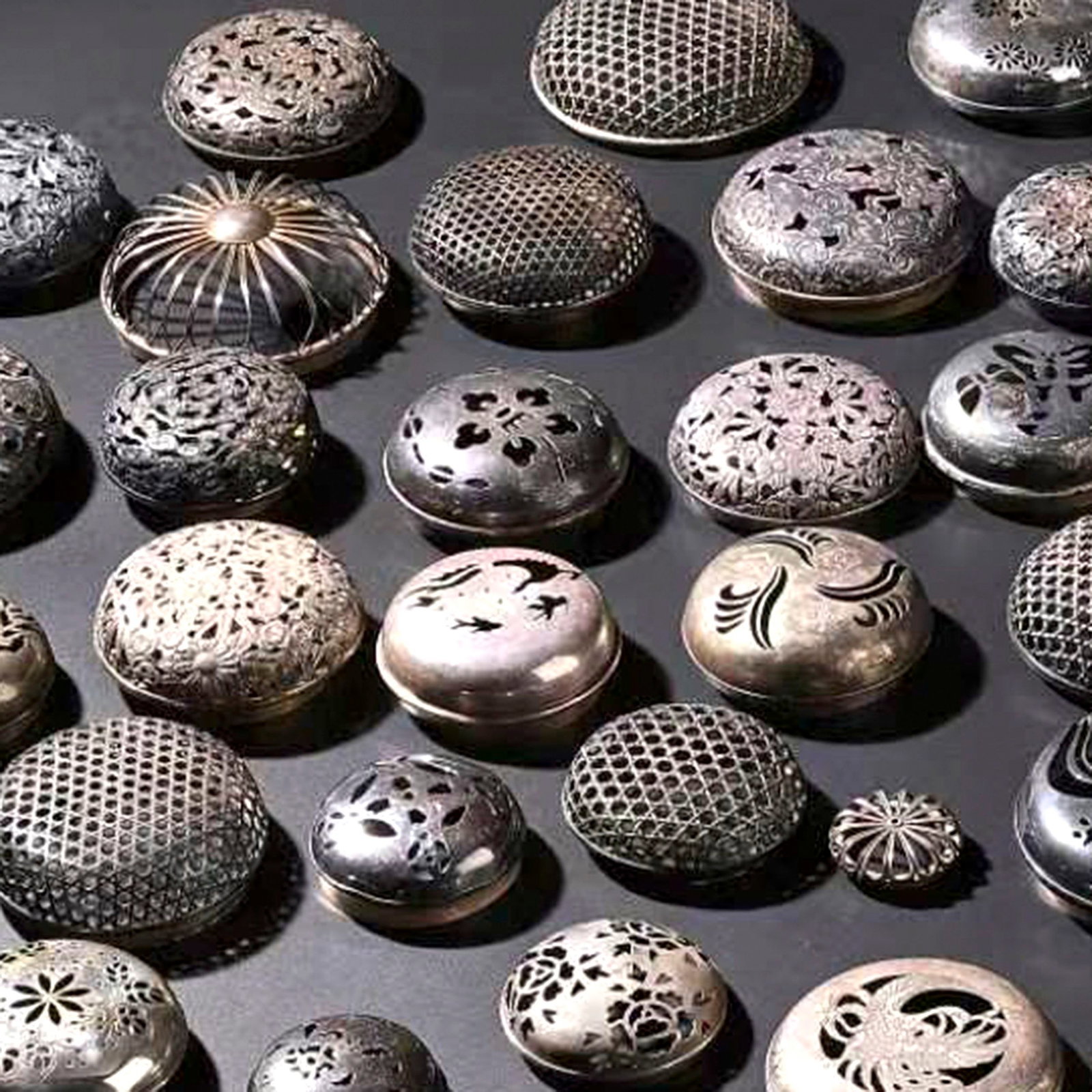 Set of 45 Silver Koro Covers: This collection comprises forty-five silver koro covers, representing a wide variety of forms and decorative techniques found in traditional Japanese metalwork. The group includes domed, flat, and hem