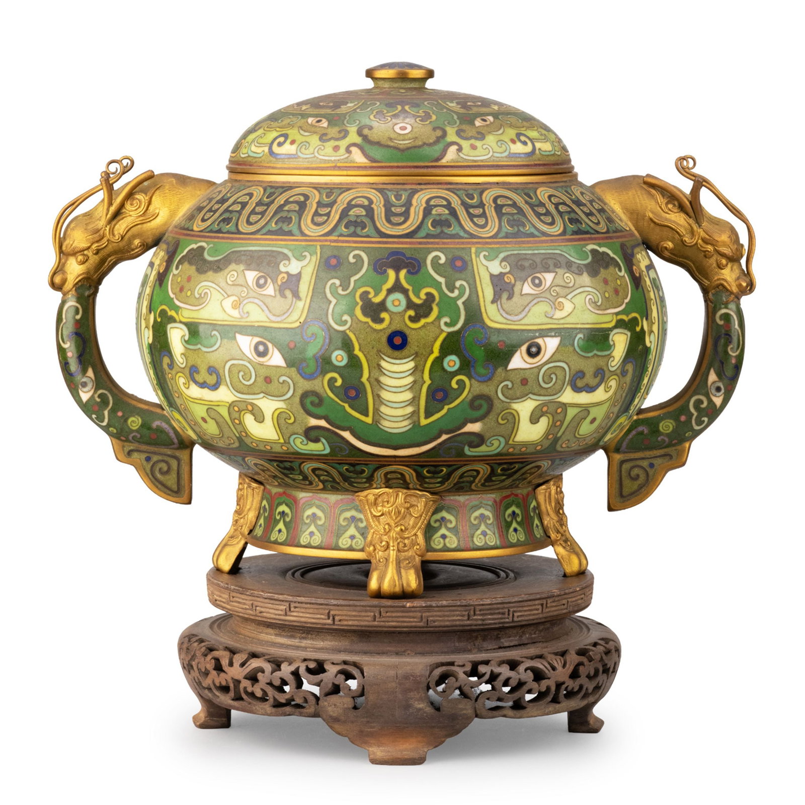 Cloisonne Covered Jar with Dragon Handles: This impressive cloisonne covered jar is crafted on a copper body with a domed cover, a pair of gilt dragon-head handles, three animal-form feet, and an accompanying carved wooden stand. The exterior 