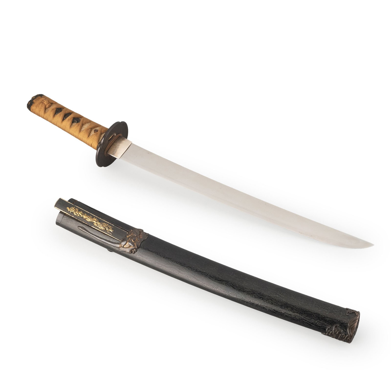 Tanto by Fujiwara Munetsugu: This elegant tanto is mounted in a refined black lacquer koshirae enriched with finely worked metal fittings. The saya is decorated with subtle carved wave motifs in relief, highlighted by a delicatel