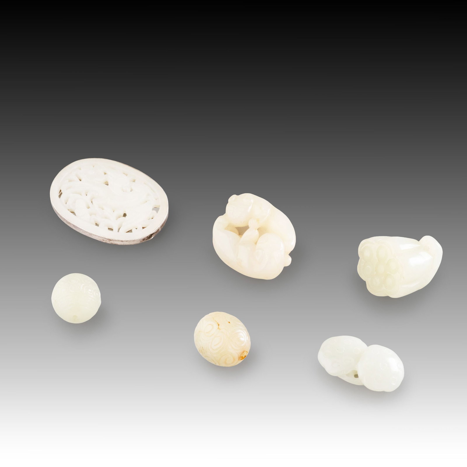 Six Jade Accessories: This collection comprises six finely carved jade ornaments, showcasing a variety of traditional forms, including an openwork plaque, mythical beast carvings, lotus pod motifs, grain-pattern beads, and