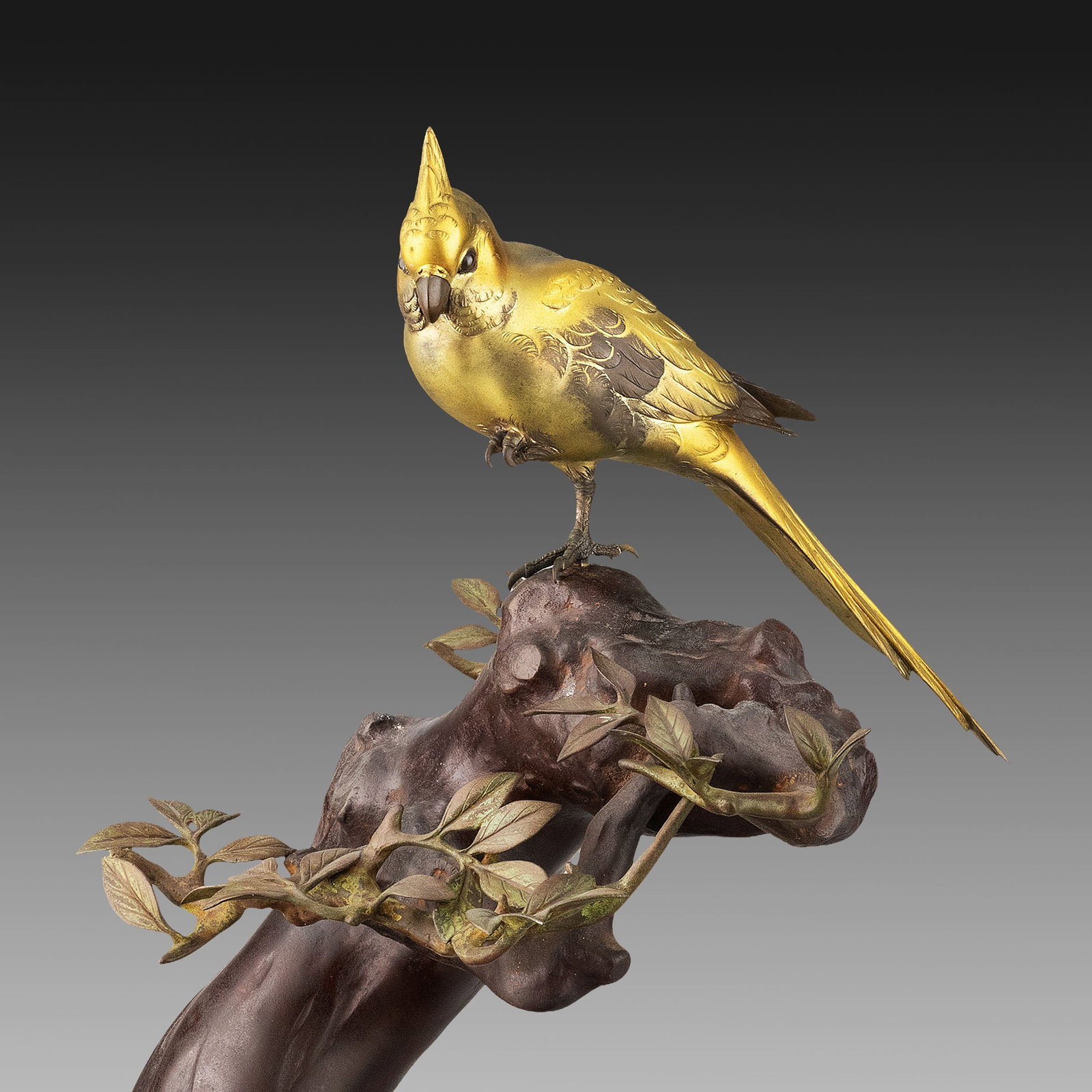 Bronze Ornament by Hideaki, Hakogaki: This bronze sculpture by Hideaki depicts a cockatiel gracefully perched upon an ancient tree trunk with delicately cast branches and foliage. The bird turns its head in a natural pose, while its raise