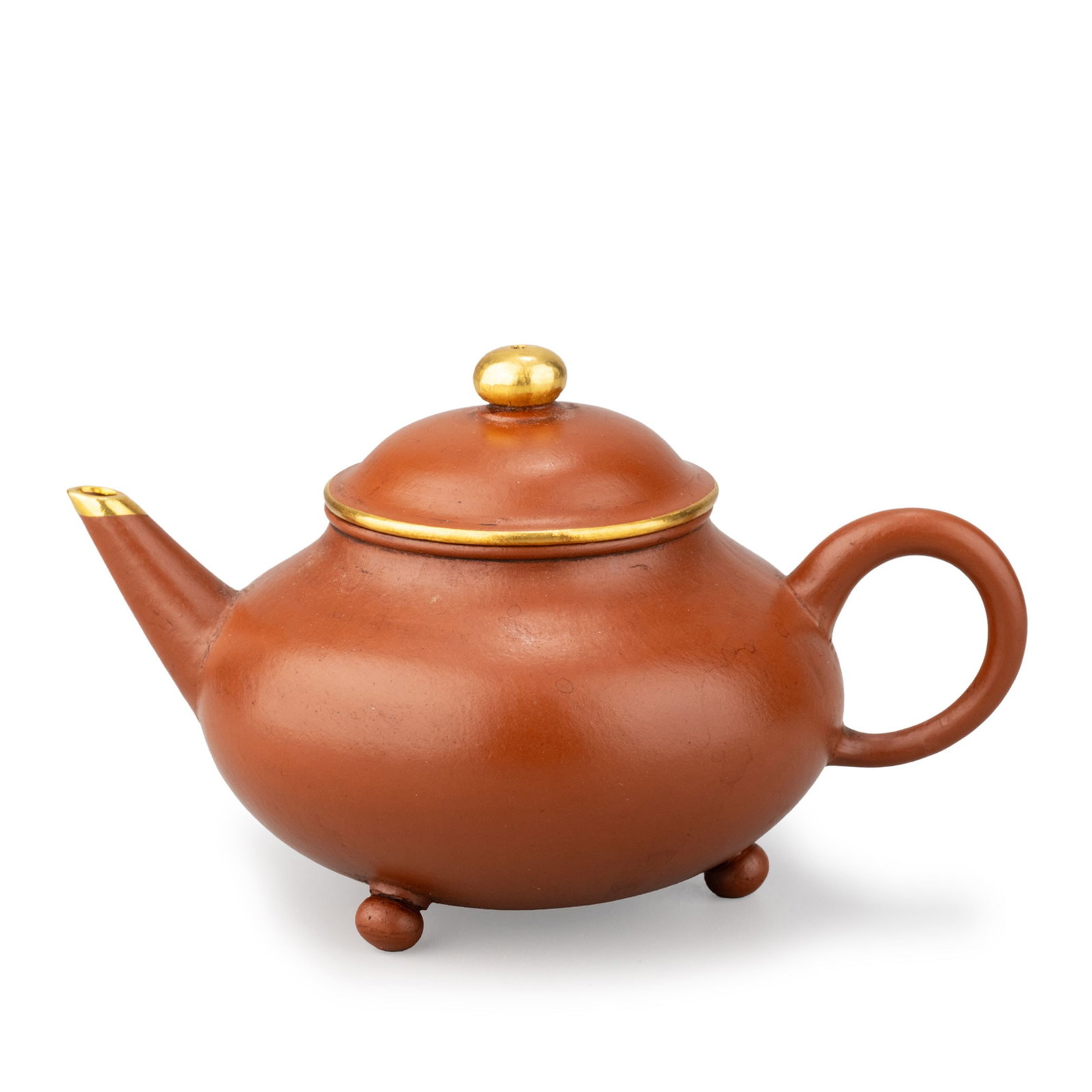 Three-Legged Teapot with Mengchen Mark: A finely potted Yixing-style red clay [zhuni] tripod teapot bearing the mark of Mengchen, of classic horizontal form with a rounded body, short spout, loop handle, domed cover, and three small feet.Th