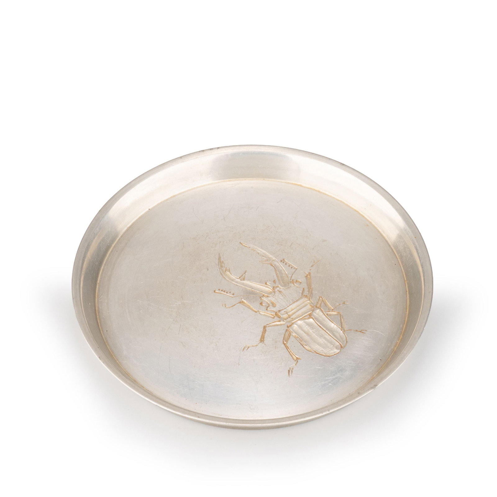 Pure Pewter Bottle Stand by Hata Zoroku IV: This finely crafted circular pure pewter bottle stand was made by Hata Zoroku IV and exquisitely engraved by the renowned metal engraver Ichikawa Tetsuro. The form is elegantly proportioned, with a su