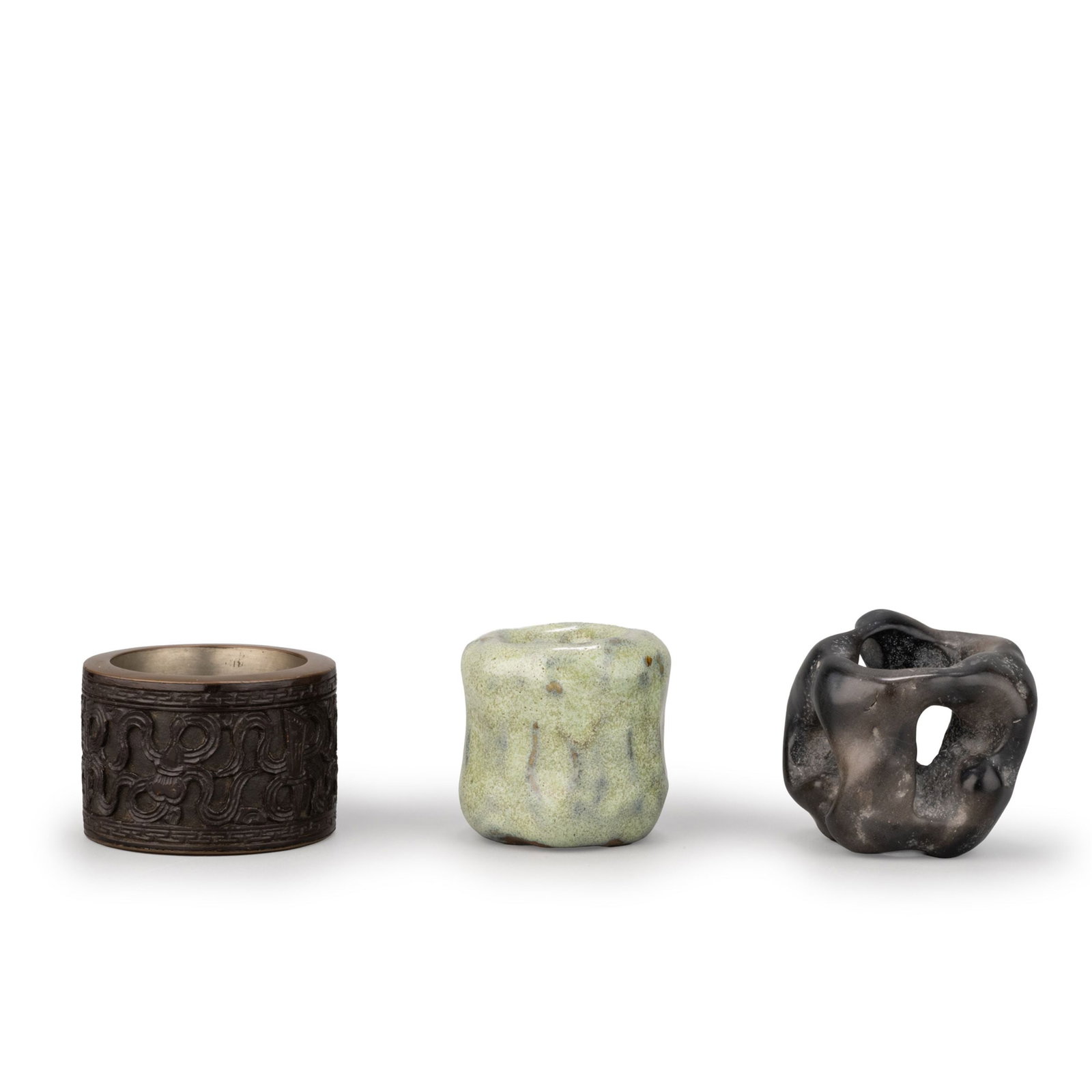 Three Tea Lid Rests: A group of three futaoki [lid rests] for the Japanese tea ceremony, executed in different materials and styles.The first is a bronze-tone metal example decorated with a continuous taotie-inspired geom