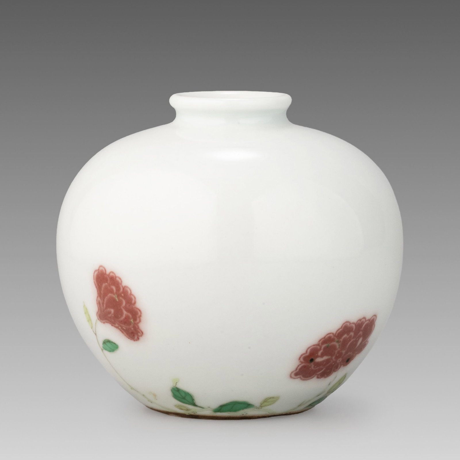 Single-Flower Vase with Yamanaka & Co. Docs: This elegant bud vase features a compact globular body with a short neck, covered in a smooth white glaze. Delicately painted in underglaze red, stylized floral blossoms are complemented by green leaf