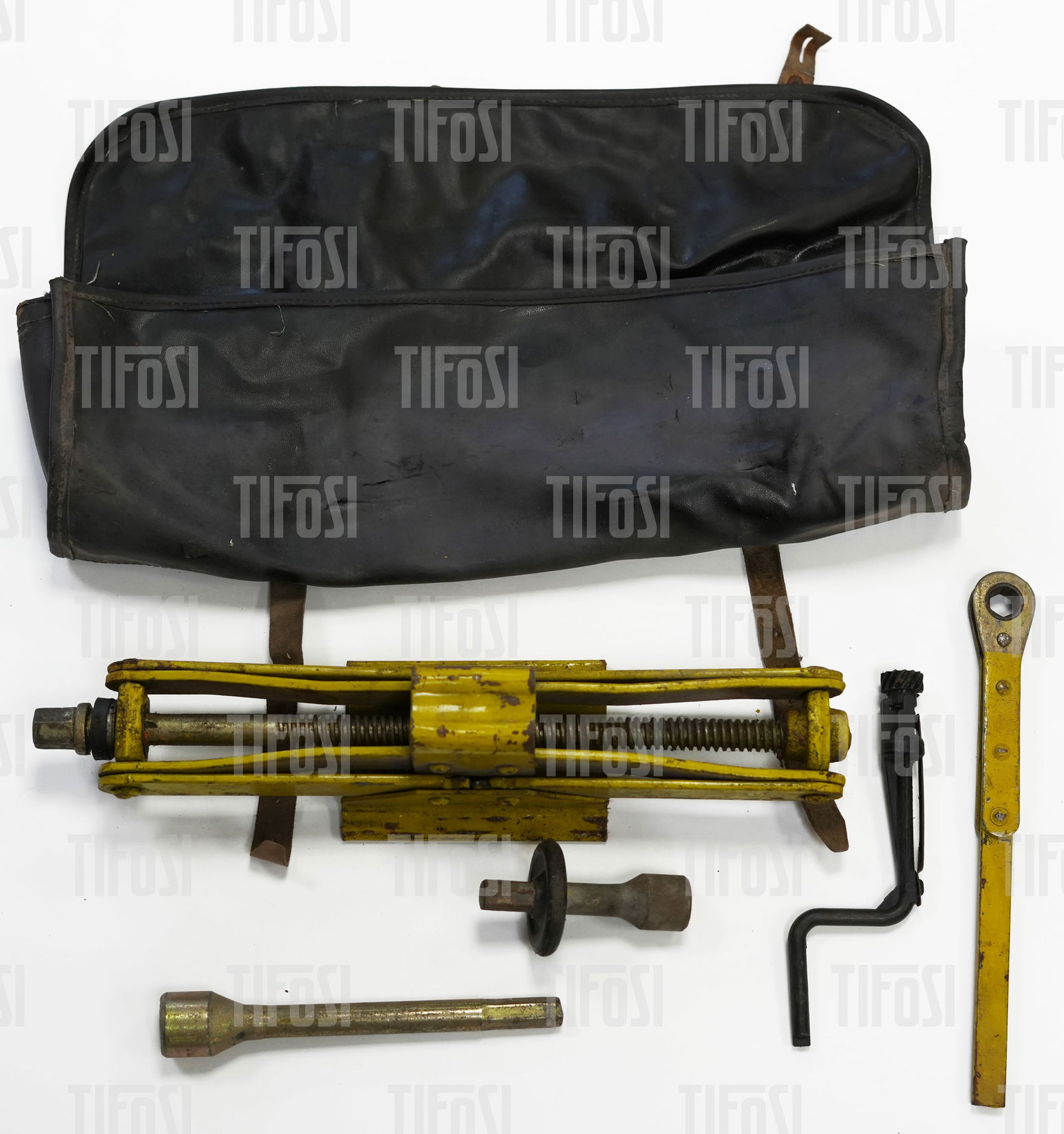 Ferrari 308 400 Jack Kit: An original Ferrari jacking kit to suit 308 and 400 cars. The kit includes the jack, extension, ratcheting handle and emergency window winder, all houses in a vinyl bag which has some tears and is