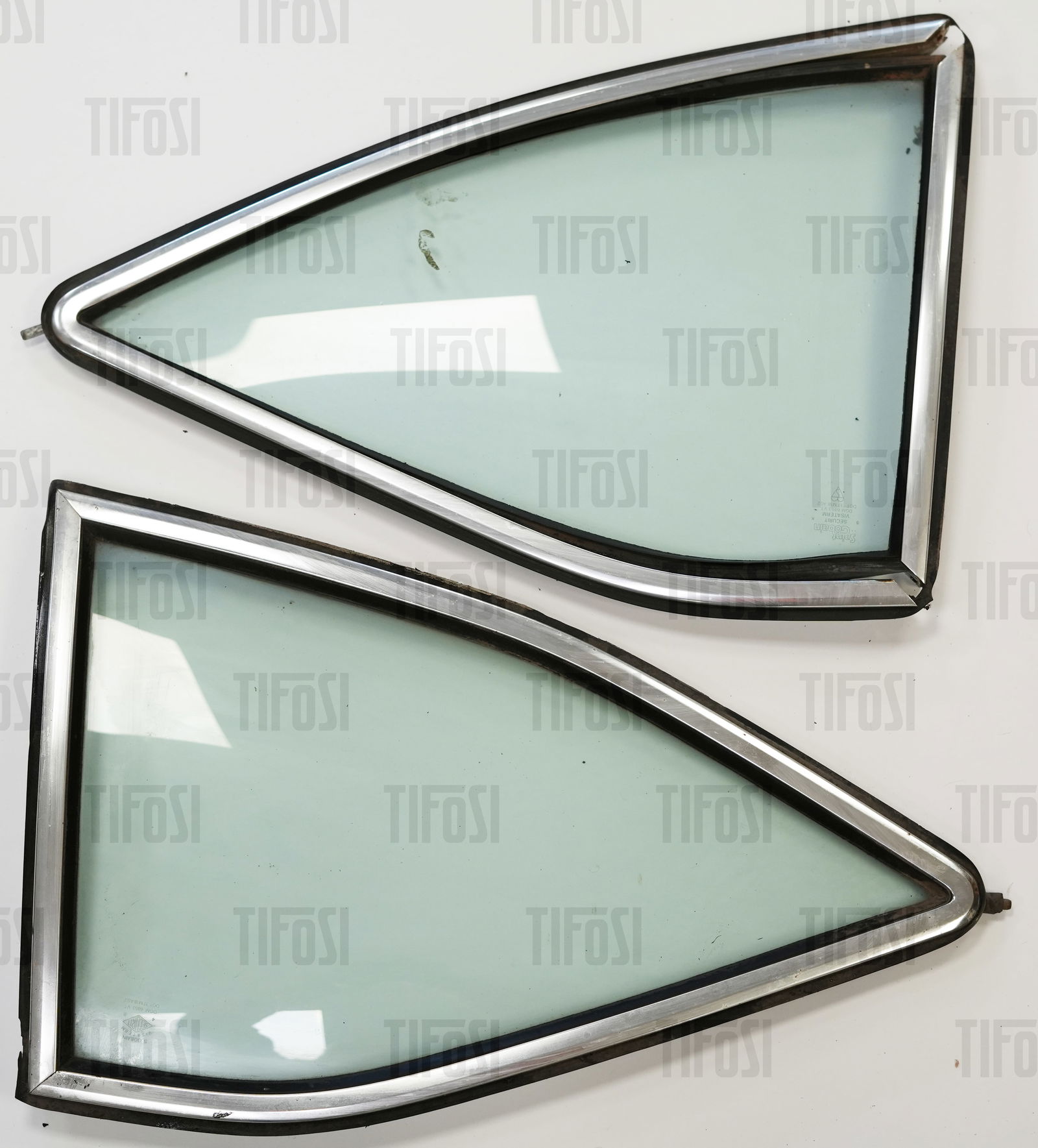 Ferrari 308 GT4 Dino Rear Quarter Glass: A pair of Ferrari 308 GT4 Dino rear quarter glasses, complete with frames and rubbers. Good condition.