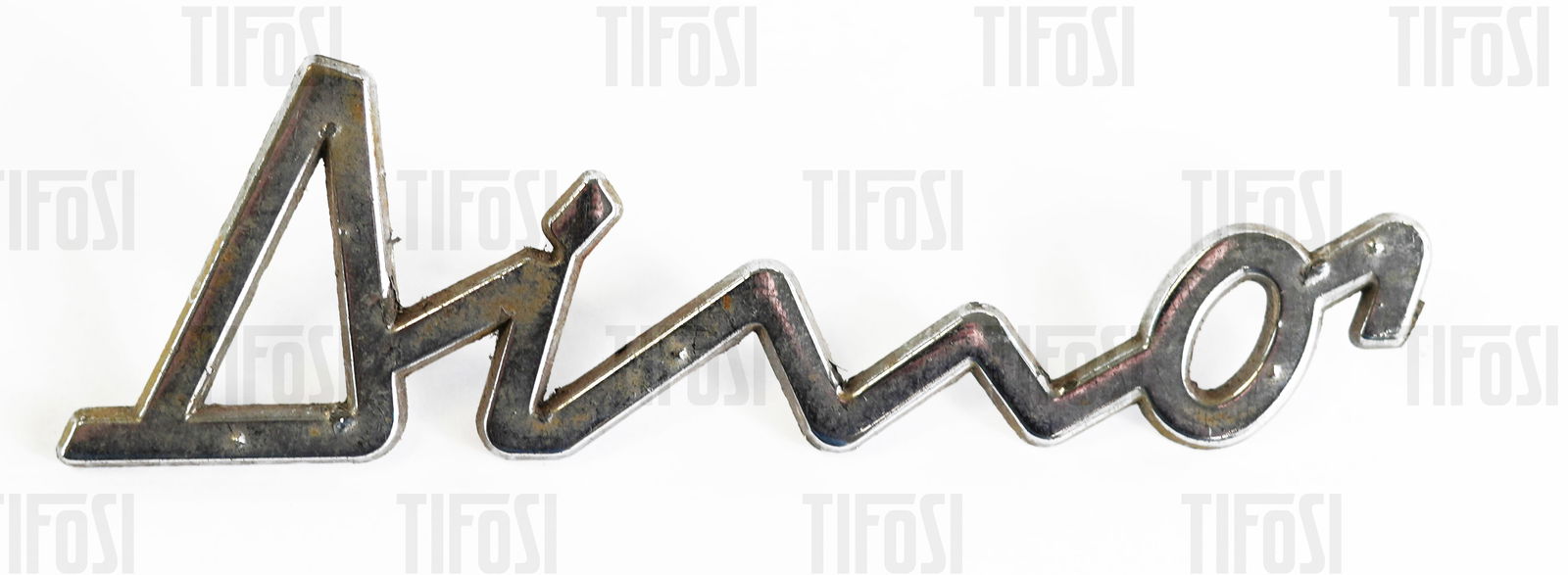 Ferrari 246 Dino Script Badge: An original Ferrari 246 Dino rear script badge, used condition.