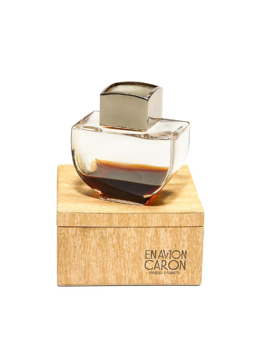 1932 Caron En Avion Perfume Bottle: 1932 Caron En Avion clear glass perfume bottle, two part stopper with openwork metal compass label sealed between layers of glass, chromed metal frame, wood grain box. *Only sold in Paris. 2 3/4 in. A