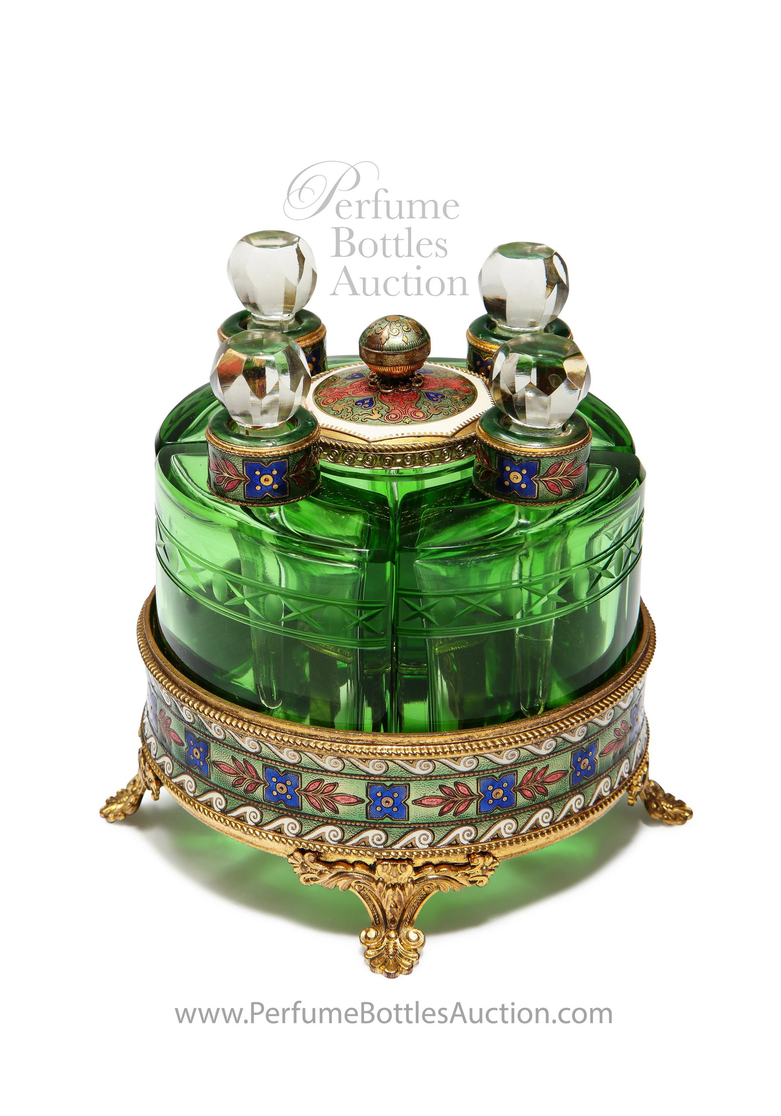 1920s Czechoslovakian vanity set, wheel-cut crystal: 1920s Czechoslovakian vanity set, 4 wheel-cut green crystal perfume bottles, clear faceted dauber-stoppers, central cream pot, enameled gilt metal lid, neck rings, and footed holder. 4 3/4 in.