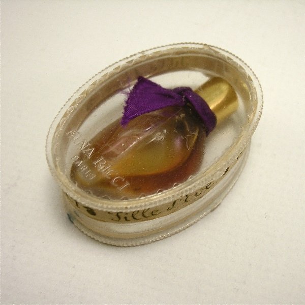 50s Nina Ricci Fille d'Eve Mini Perfume Bottle: 113. 1950s Nina Ricci Fille d'Eve mini perfume bottle as a leaf in frosted glass, screw cap, ribbon, label, in plastic box. 1 3/4 in.