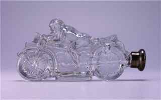 1910s English Crystal Motorcycle Scent Bottle: 1910s English figural scent bottle in clear glass formed as a motorcycle and rider, with silver screw pressure cap. London silver mark. Molded marks in glass. L. 4 in.