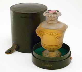 R. Lalique Guerlain Perfume Bottle: R. Lalique Guerlain Bouquet de Faunes perfume bottle and stopper, frost glass, grey patina, sealed, metal grommets, label, box. Minor base chip (possible mold bubble) not visible on stand. 3 7/8 in.