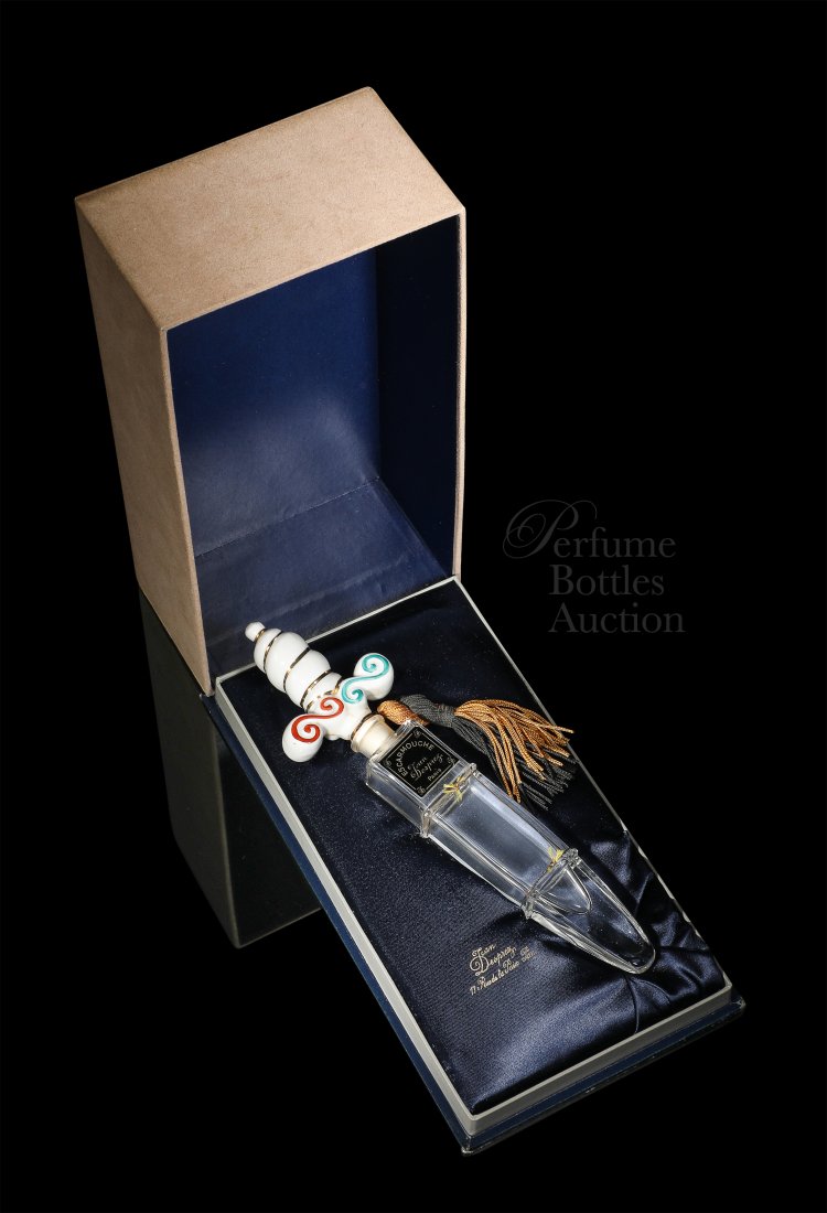 Jean Desprez Escarmouche perfume bottle: 1950 Jean Desprez Escarmouche (Skirmish) perfume presentation as a dagger, a clear glass perfume bottle forming the blade, a hand decorated porcelain handle as the stopper, tassel, label. Beige suede