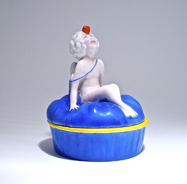 1920s Etling-Paris powder box, decorated porcelain, a c: 1920s Etling-Paris powder box, decorated porcelain, a cupid with quiver on back, balancing “Love” on his forehead. Maker and Etling marks. 4 1/2 in.