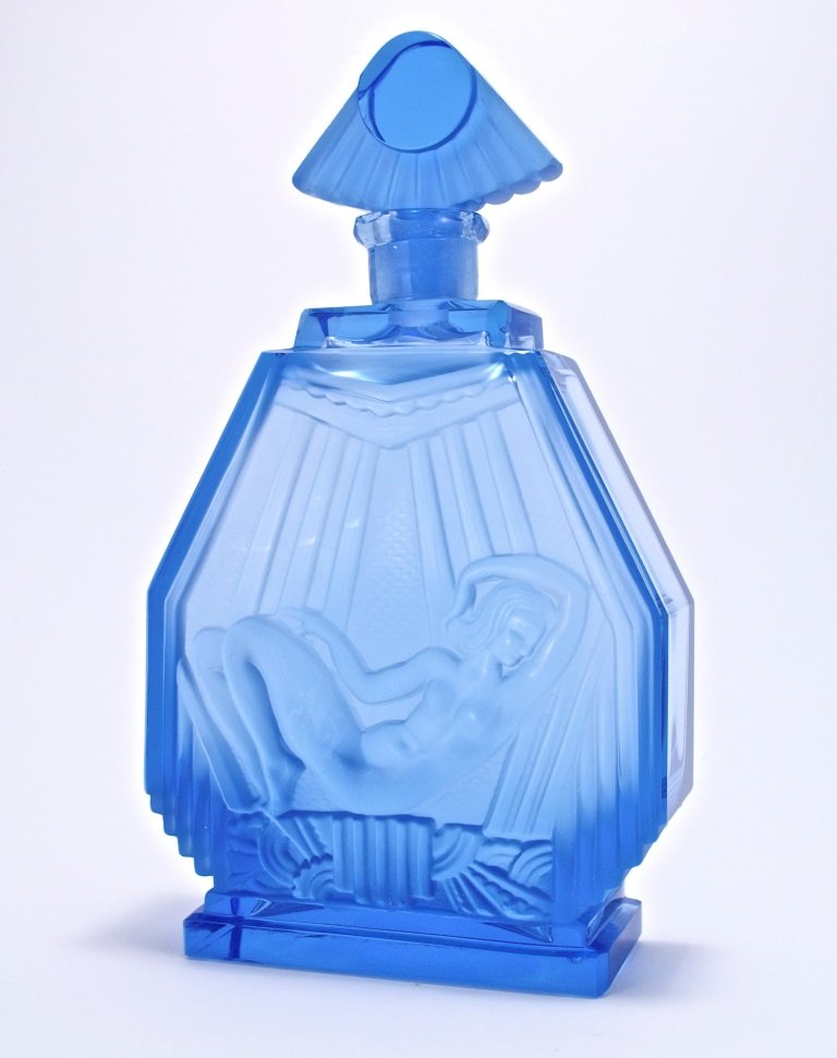'1930 Czech Blue Crystal Perfume Bottle: c1930 Czechoslovakian perfume bottle and stopper, clear/frost blue crystal. Reclining nude basks in the rays of the stylized sun stopper. 7 7/8 in.