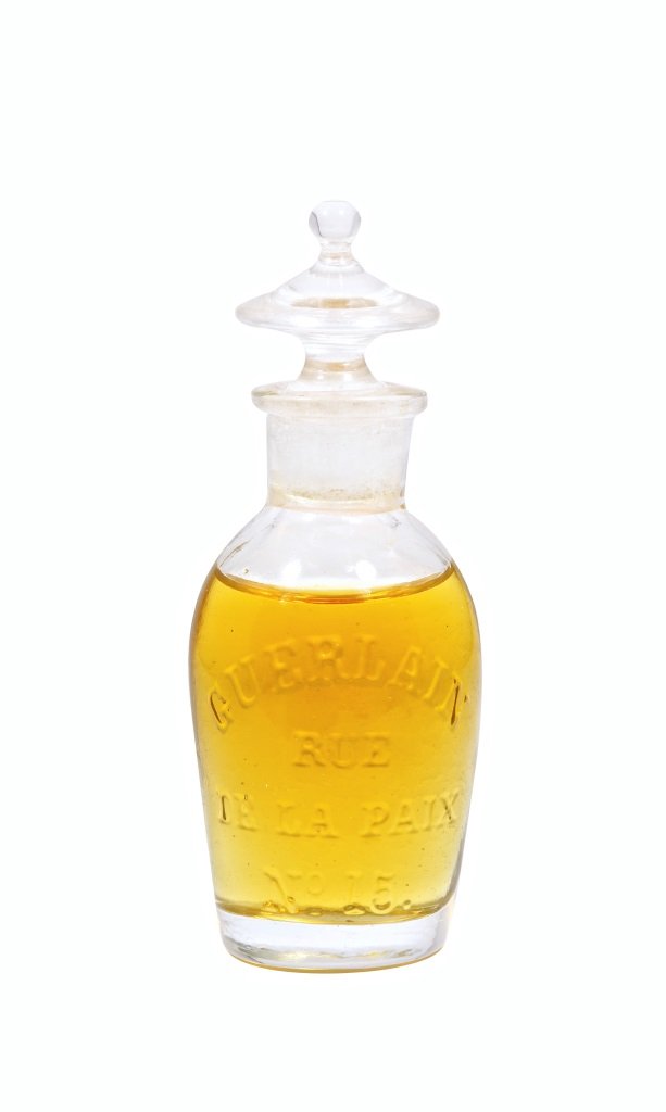 1830 Guerlain Early Perfume Bottle: 1830 Guerlain perfume bottle and stopper, used for various scents, clear glass, molded address label., edge chipping on stopper plug. *Named “L’urne Antique” by Atlas and Monniot in Guerlain pg.