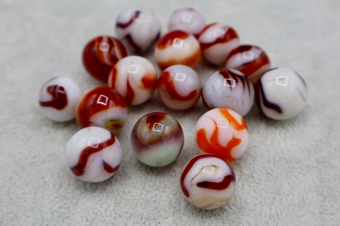 WV Mixed Group of Red Flame Swirl Marbles: A vintage grouping of WV Swirls. Some flames, Mostly Alley agate and some fine examples at that. All are approximately 5/8” and in excellent condition.