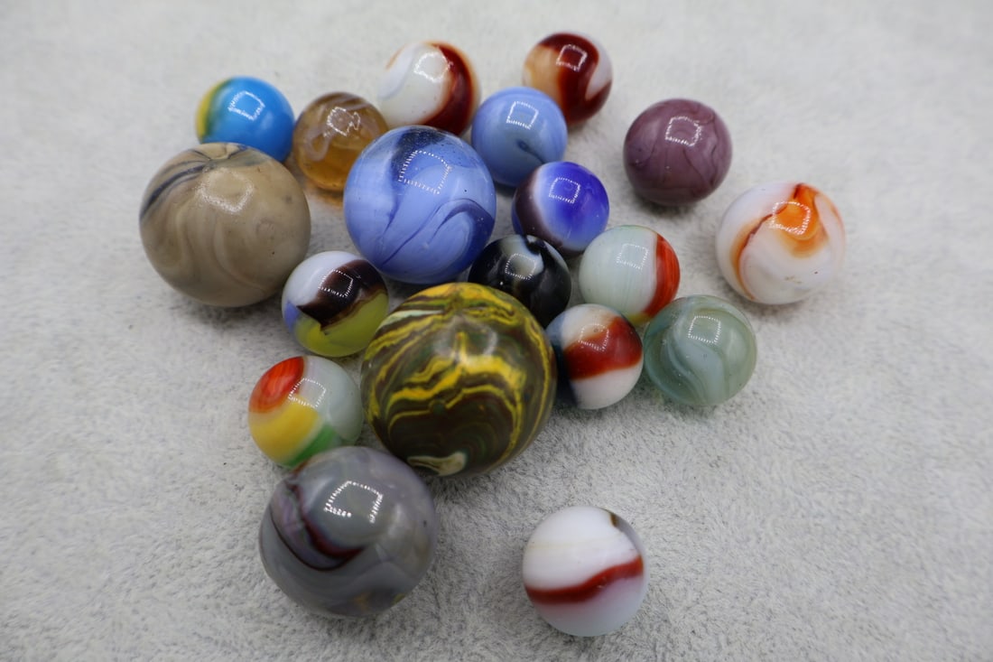 A Grouping of Various Vintage Marbles: Various makers. Various Types like swirl, agate, flame and patch. Various conditions. A variety of vintage marbles from a lifelong collection. Lot 39