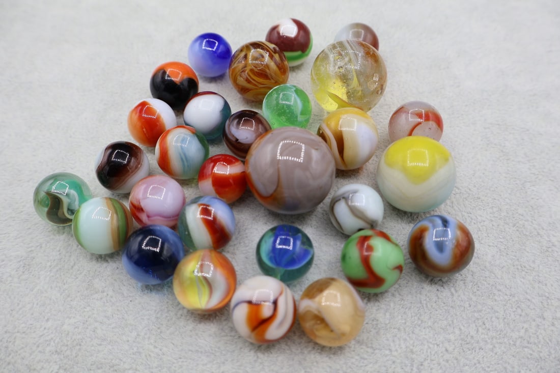 A Grouping of Various Vintage Marbles: Various makers. Various Types like swirl, agate, flame and patch. Various conditions. A variety of vintage marbles from a lifelong collection. Lot 40