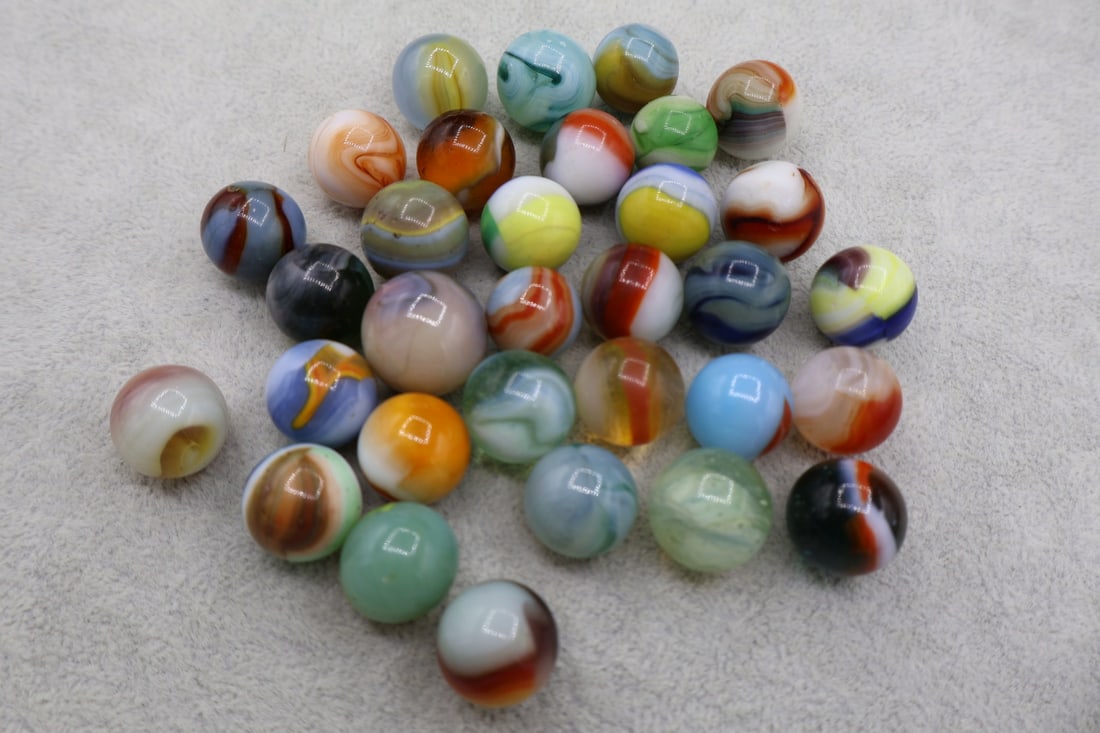 A Grouping of Various Vintage Marbles: Various makers. Various Types like swirl, agate, flame and patch. Various conditions. A variety of vintage marbles from a lifelong collection. Lot 42