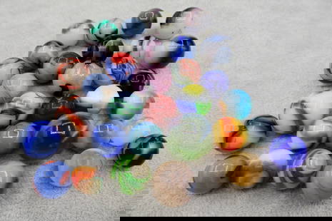 A Grouping of Various Vintage Marbles: Various makers. Various Types like swirl, agate, flame and patch. Various conditions. A variety of vintage marbles from a lifelong collection. Average size 5/8&rdquo; to 1&rdquo;. Lot 61