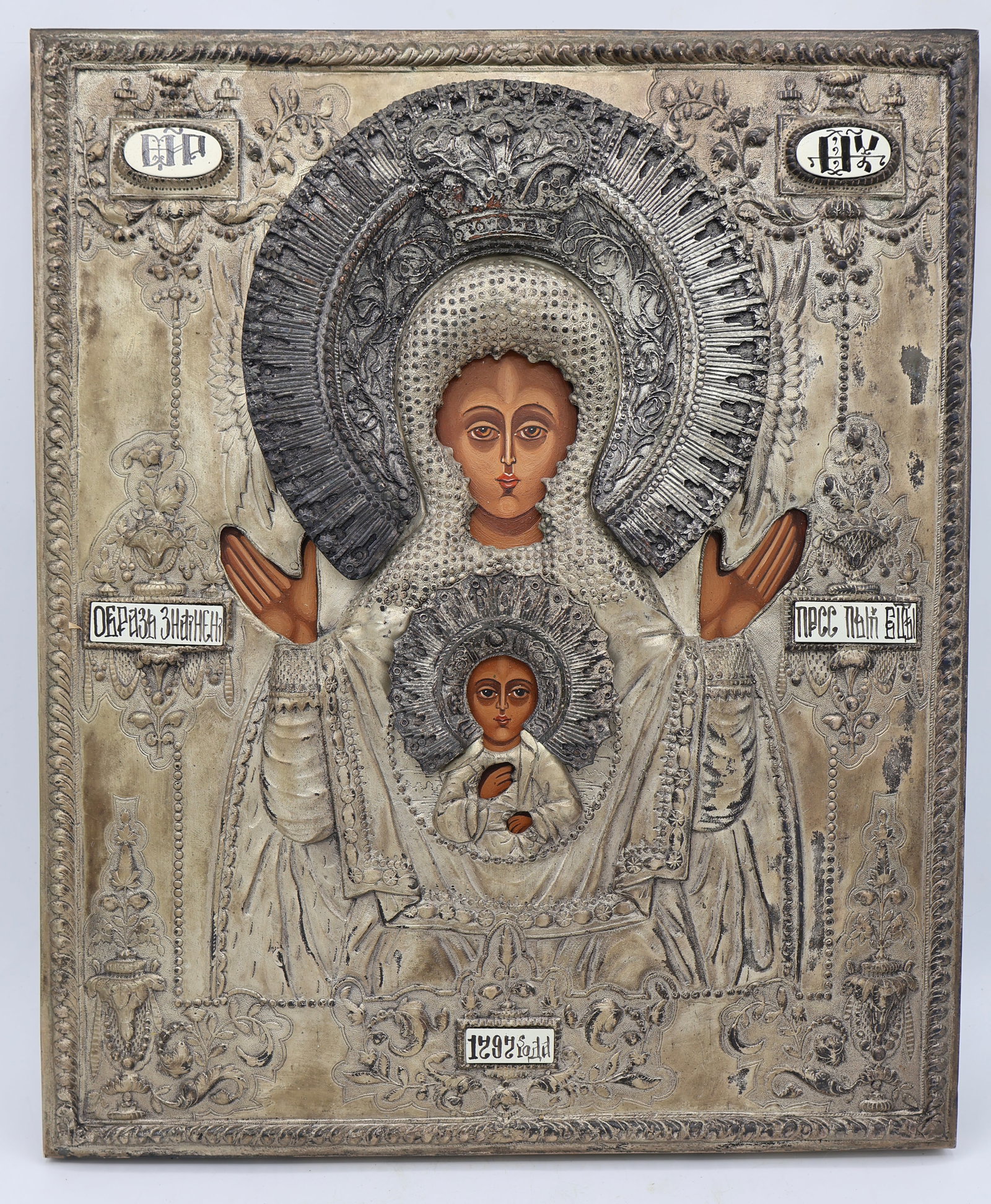 A Russian Icon Mary and Christ Child: A hand painted and handmade icon of Mary and Christ Child. Silver clad OKLAD. Finely detailed. Hand hammered and embellished covering with porcelain sections.