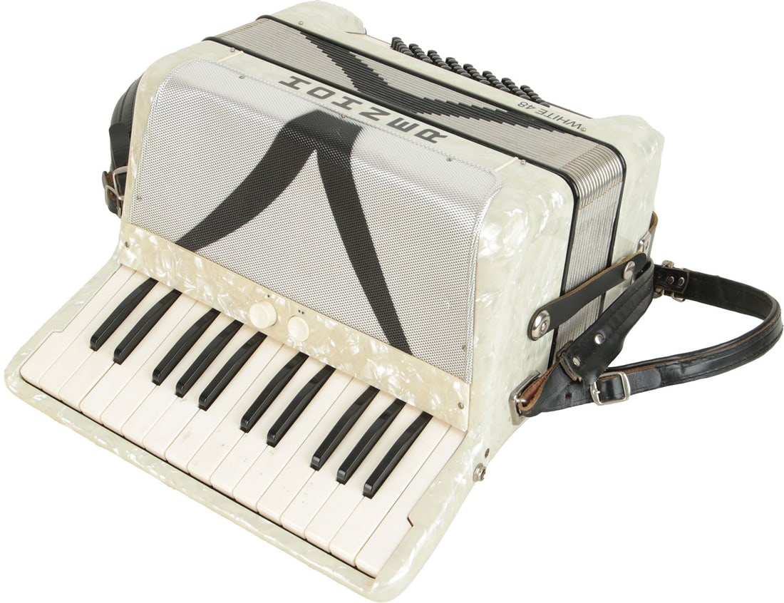 Hohner White 48 Accordion: 26 keys, 48 bass. Keyboard 12.5". 2 registers. White marble finish with black design to grille and bellows. Comes with leather strap. Made in Germany. Weight 4.6kg. Light marks to keys.