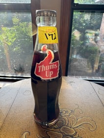 Thums Up Glass Bottle with dark liquid